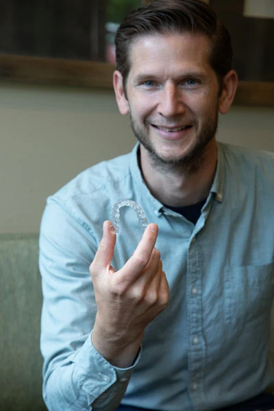 Dr. Tebay holding Invisalign clear aligners