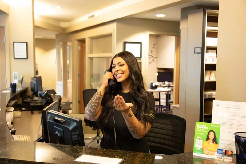 The front desk at dentistry treatment at Olympia Advanced Dentistry scheduling a dental crown consultation.