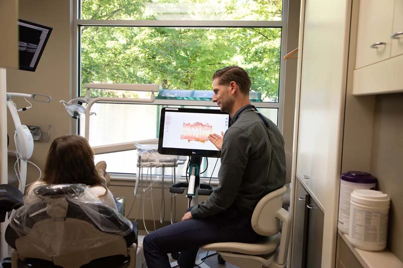 Dentist, Dr Tyler Tebay discussing oral surgery options with a patient at Olympia Advanced Dentistry