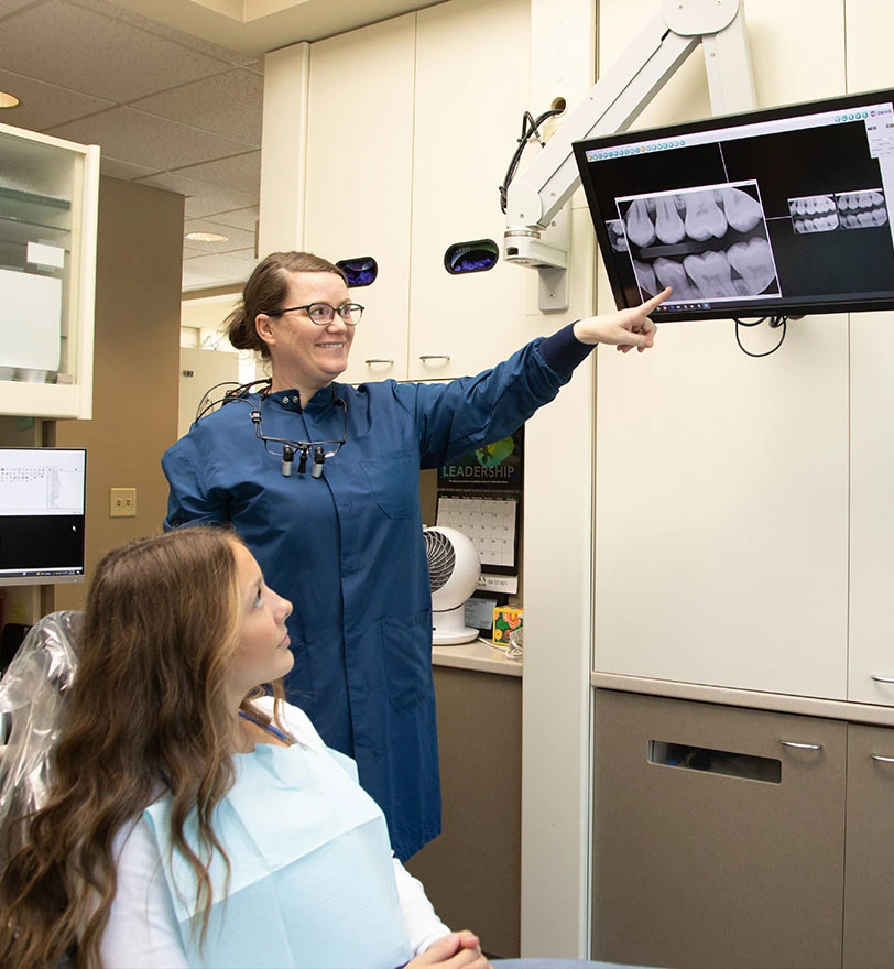 patient speaking with a staff member pointing at an x-ray at Olympia Advanced Dentistry in Olympia, WA